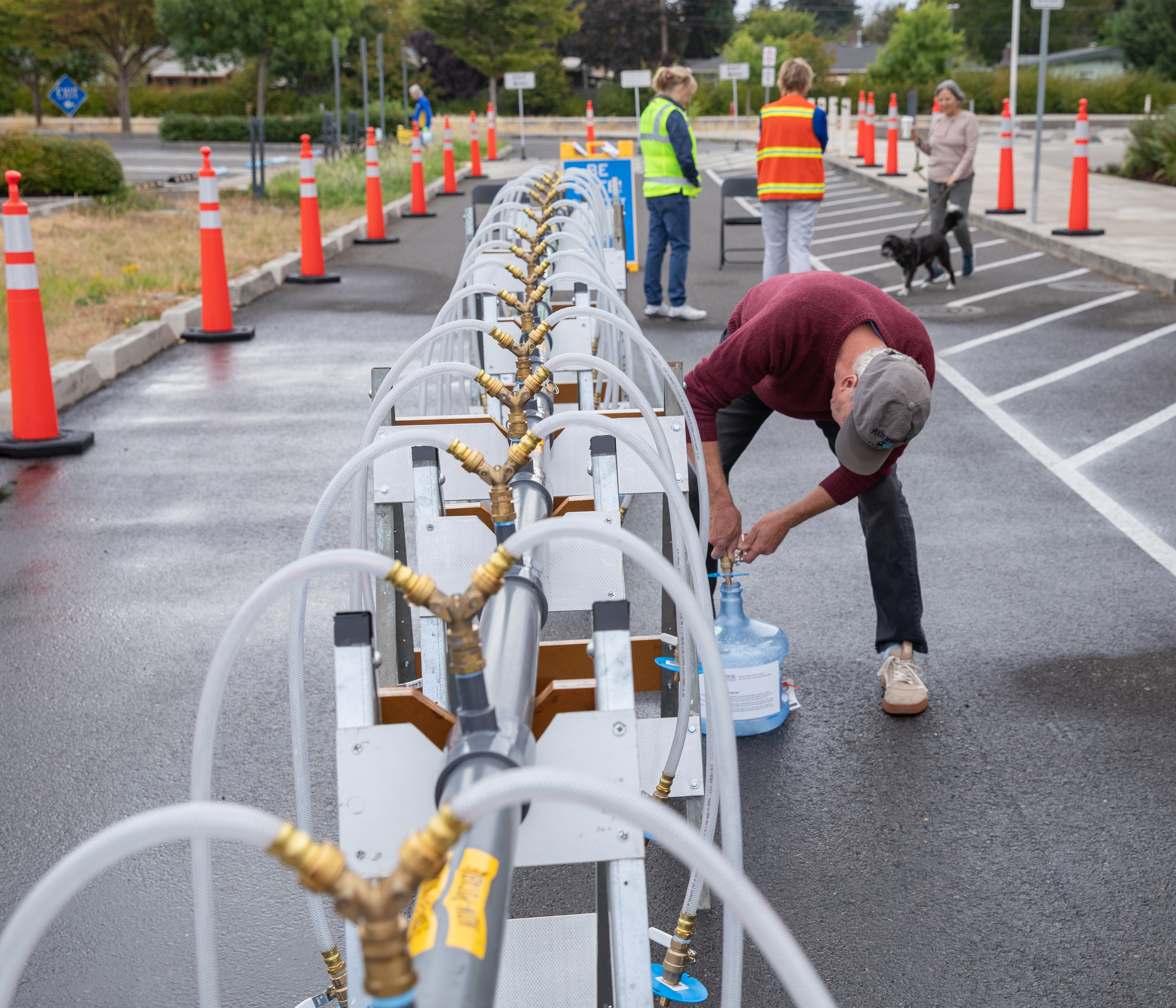 Community member fills water jug at emergency water station event at Howard Elemntary school
