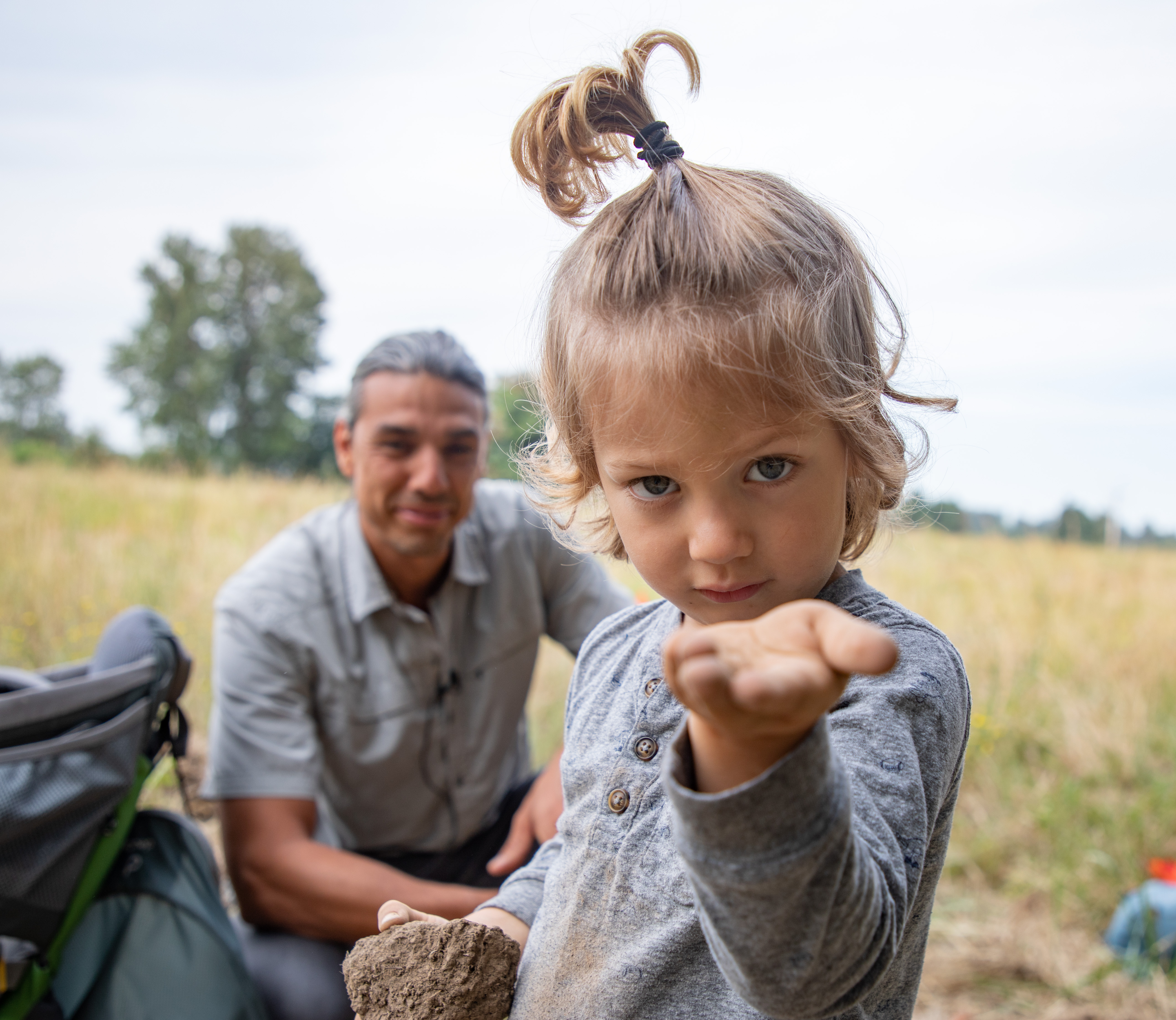 Dr. Silva's son holds a dirt clod - a soil "aggregate" - that is the key to long-term carbon sequestration