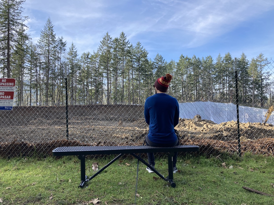 A man sitting on newly installed bench at E. 40th construction site