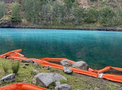 river with white cloudy area, orange inflatable device on riverbank