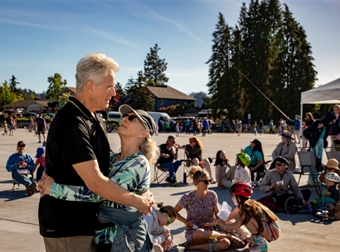 Couple dancing with revelers in the background at Farewell College Hill event