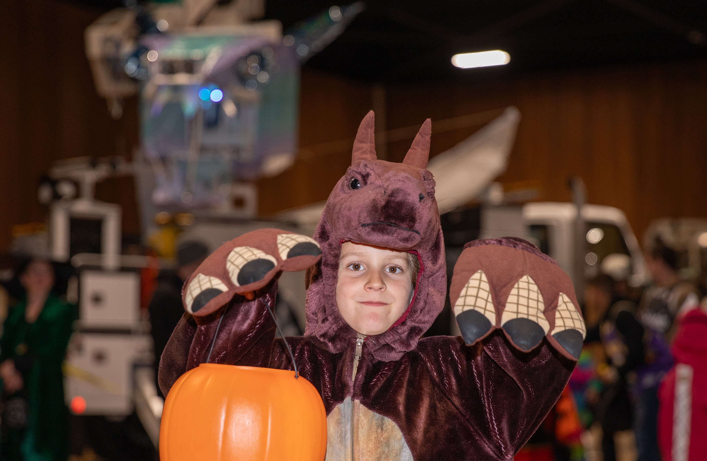 A child dressed as a dragon poses in front of an EWEB truck dressed as a dragon.