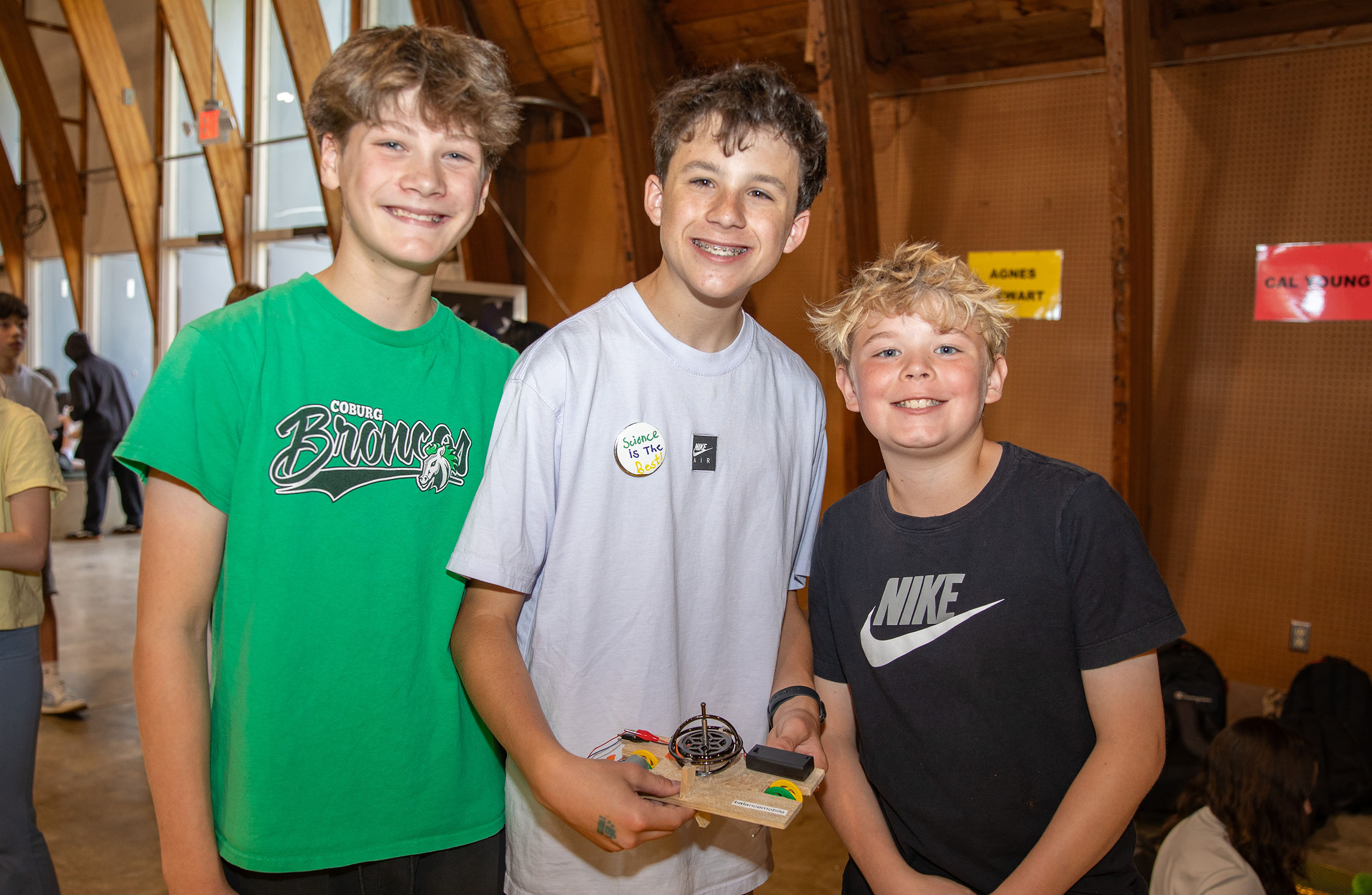 Three students show their gyroscope car