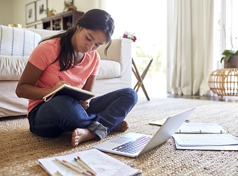 Girl sitting on the floor doing homework