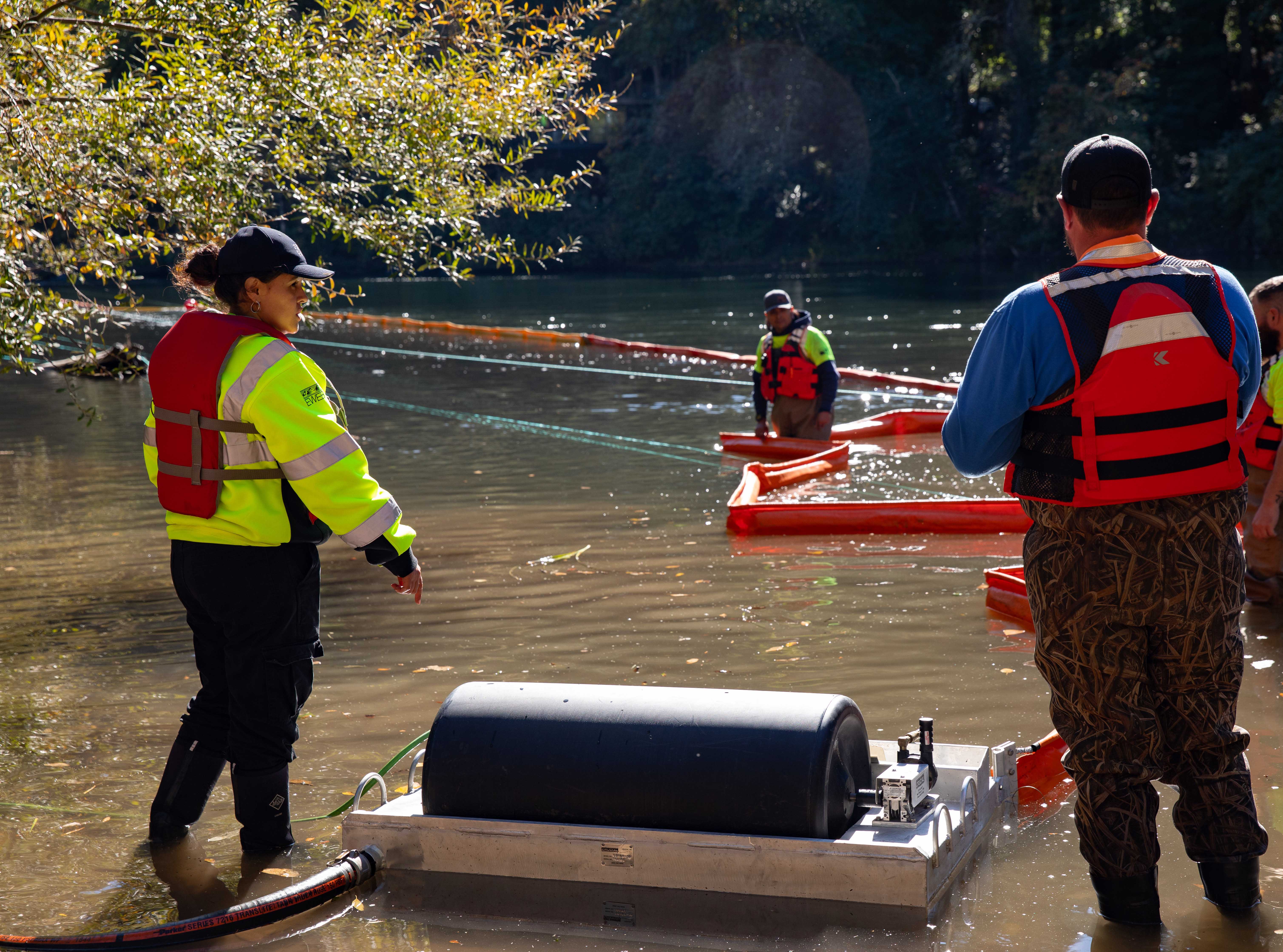 EWEB and SUB staff position an oil skimmer in the river.
